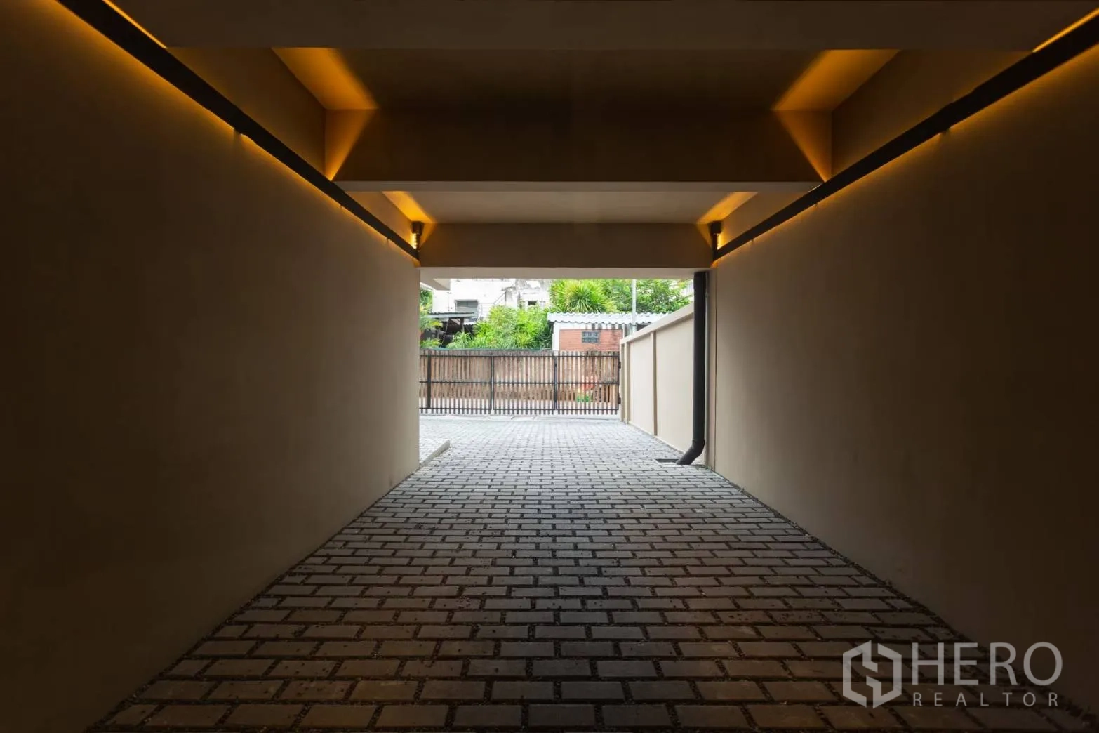 Home Office for rent in Watthana, Bangkok - Covered driveway tunnel with brick paving leading to gated entrance.
