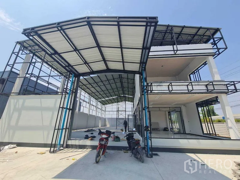 Warehouse for rent in Bang Len, Nakhon Pathom - Front view of high-clearance loading canopy beside a glass-fronted two-storey office wing at the warehouse.