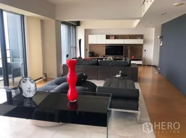 Condominium for rent in Sathon, Bangkok - Stylish living room with black leather sofa and modern decor