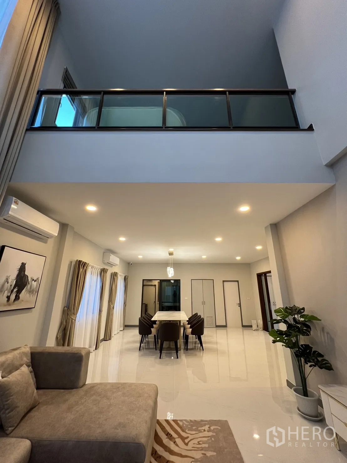 Detached House for rent or sale in Bang Phli, Samut Prakan - Living room facing dining area with bright recessed lighting and glossy floors.
