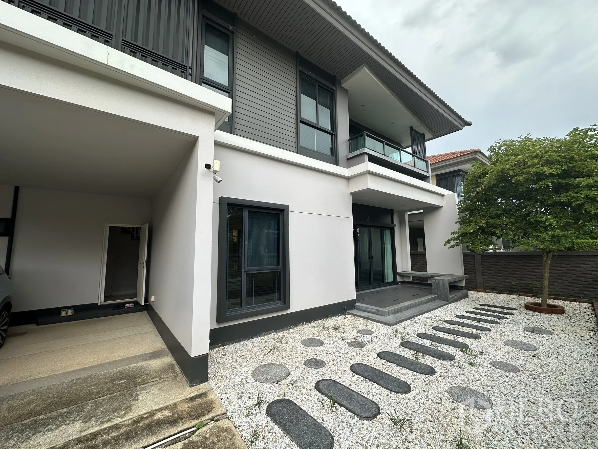 บ้าน ให้เช่าในLam Luk Ka, Pathum Thani - สวนหน้าบ้านโรยหินสีขาว ทางเดินแผ่นหิน และโรงจอดรถ