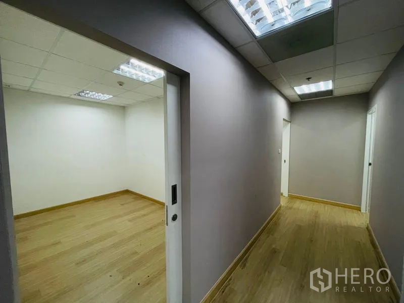 Office Space for rent - Hallway with sliding door opening to a white-walled office.