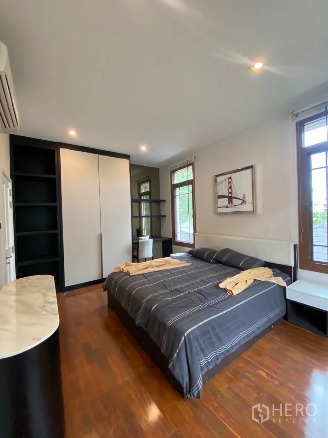 Detached House for rent in Bang Phli, Samut Prakan - Secondary bedroom with large bed, built-in wardrobes, shelving and windows.