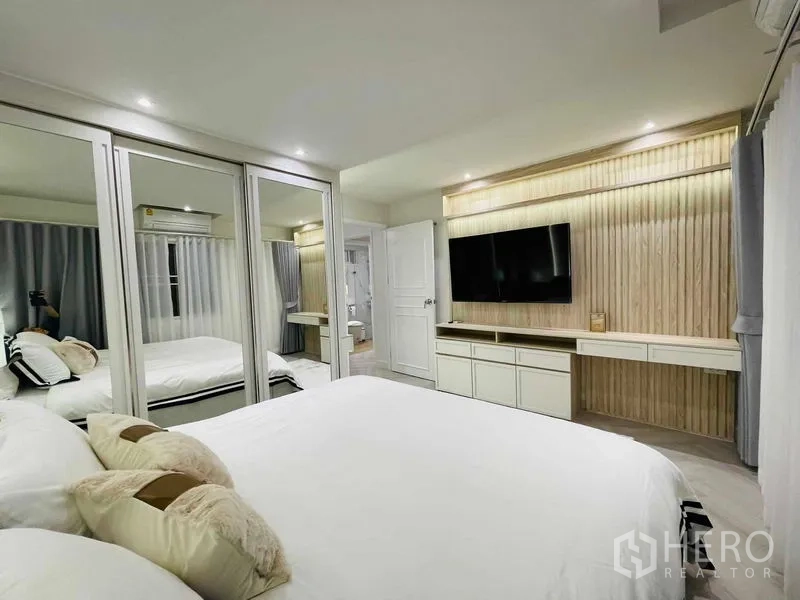 Condominium for sale in Yan Nawa, Bangkok - Master bedroom wall with mounted TV, long console, and mirrored wardrobes.