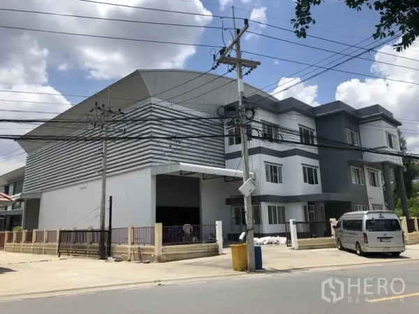 货栈 出租或出售在Lam Luk Ka, Pathum Thani - 街景：现代仓库配三层办公楼，带大门与装卸通道，位于 Lam Luk Ka。