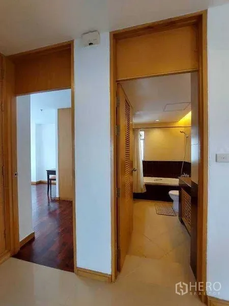 อพาร์ทเมนท์ ให้เช่า - โถงทางเดินมองเข้าหาห้องน้ำและห้องสว่างพื้นไม้
