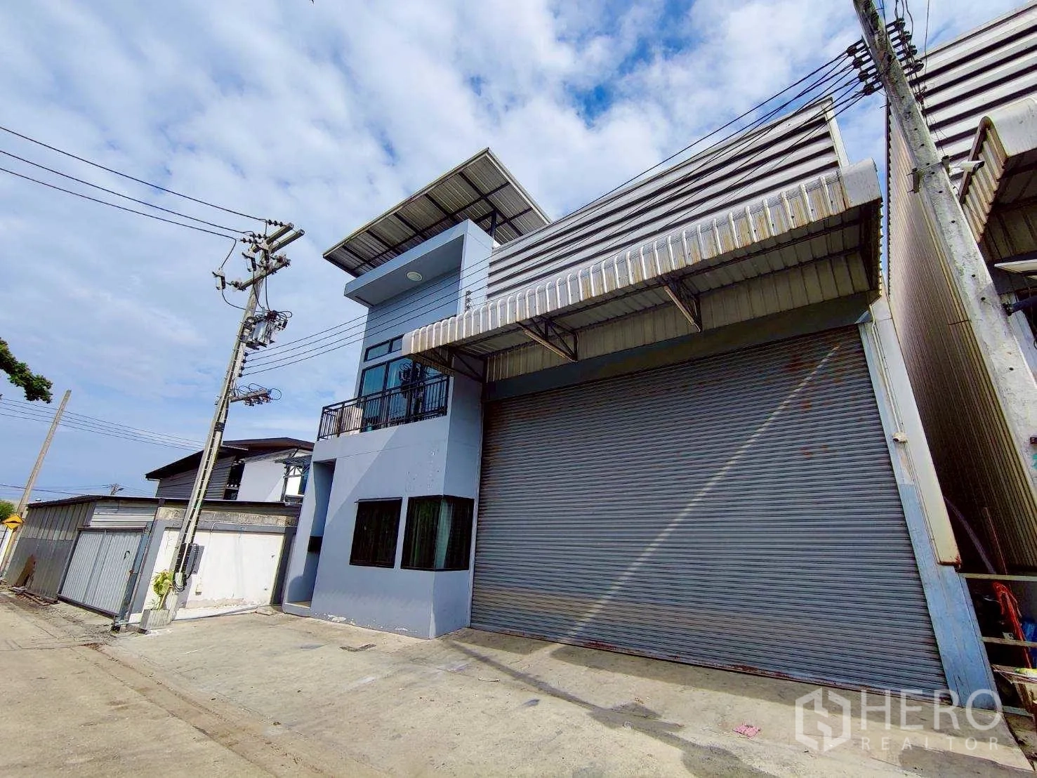 Warehouse for rent in Lam Luk Ka, Pathum Thani - Large warehouse space with office corner, fire extinguisher and shutter access.