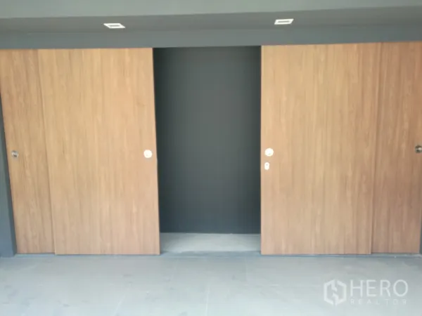 Townhouse for rent or sale in Suan Luang, Bangkok - Wide wooden sliding doors providing enclosed storage or parking access.