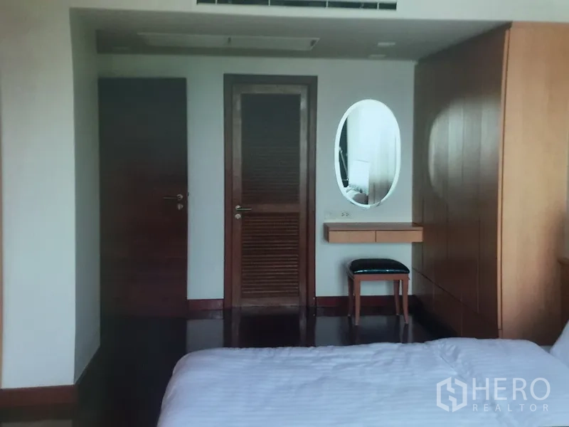 คอนโด ให้เช่าในWatthana, Bangkok - มุมห้องนอนใหญ่ ตู้เสื้อผ้าบิลท์อิน โต๊ะเครื่องแป้งกระจก และประตูไม้