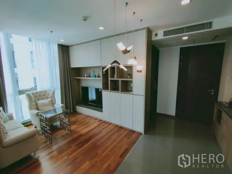 คอนโด ให้เช่าในRatchathewi, Bangkok - ห้องนั่งเล่นสว่าง โปร่ง โล่ง พร้อมโซฟา ชุดชั้นวางทีวี และหน้าต่างกระจกสูงจรดเพดานกับผ้าม่านโปร่ง.