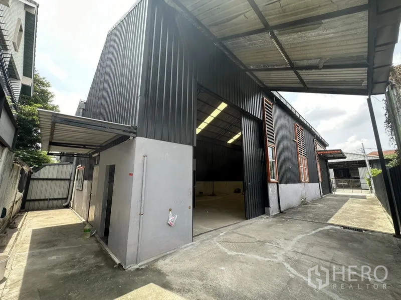 คลังสินค้า ให้เช่าในLat Phrao, Bangkok - ทางเข้าโกดังประตูบานเลื่อนสูง มีพื้นที่โหลดของมีหลังคาและลานคอนกรีต