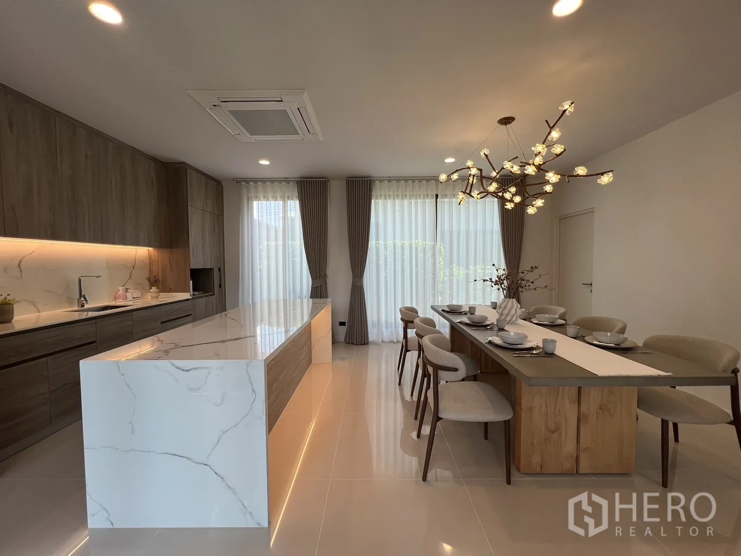 Detached House for rent or sale in Bang Kapi, Bangkok - Marble waterfall kitchen island with built-in cabinetry and soft lighting.