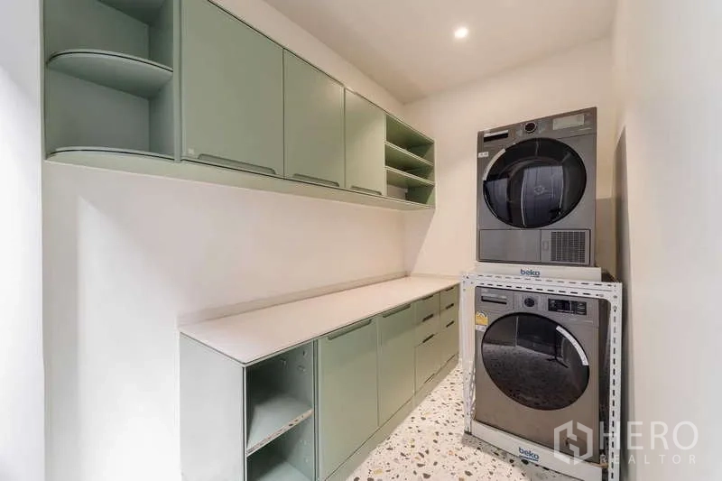 ทาวน์เฮาส์ ให้เช่าหรือขายในWatthana, Bangkok - ห้องซักรีดพร้อมตู้สีเขียวและเครื่องซักผ้า-อบผ้าซ้อนกัน