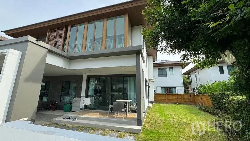 Detached House for rent in Prawet, Bangkok - Rear facade of the house with covered patio opening to a large lawn.