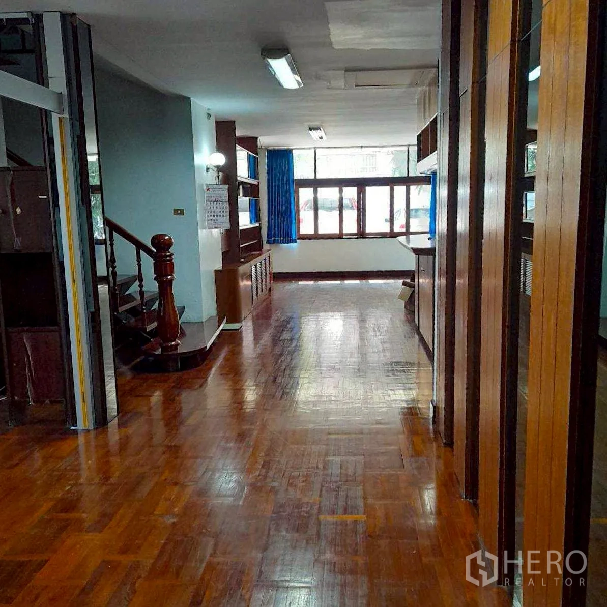 Home Office for rent in Bang Rak, Bangkok - Long hall with wooden staircase, shelving and front windows.