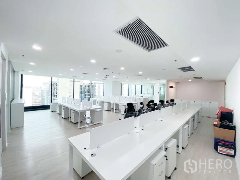 办公空间 出租在Din Daeng, Bangkok - 转角办公室配长条工位，落地窗带城市景观，天花设中央空调出风口。