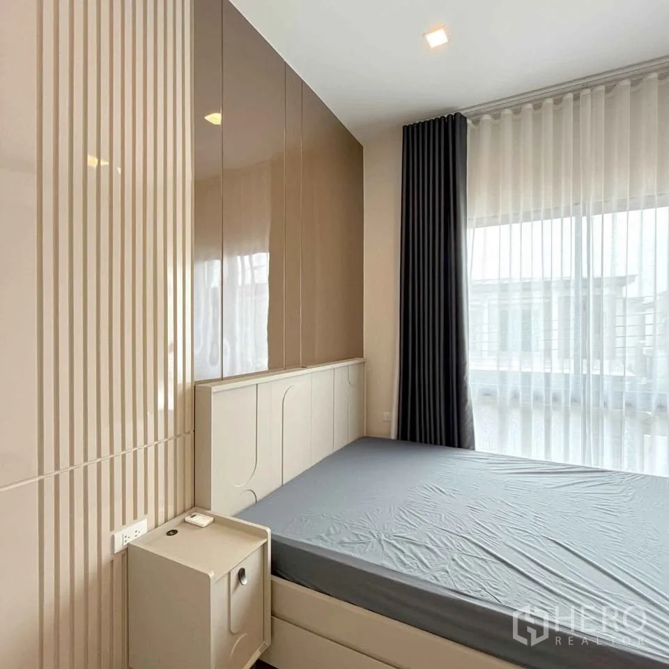 Detached House for rent in Bang Phli, Samut Prakan - Bedroom with tall curtains, glossy storage and bed with side table.