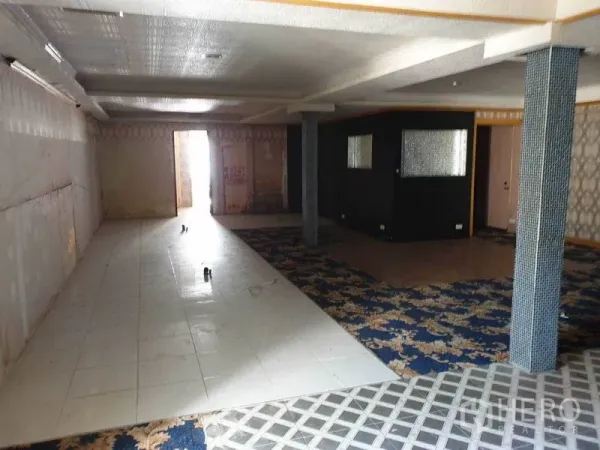 零售空间 出租在Khlong Toei, Bangkok - 宽敞的零售室内空间，瓷砖步道与花纹地毯分区，吊顶与立柱，通向后方门口。