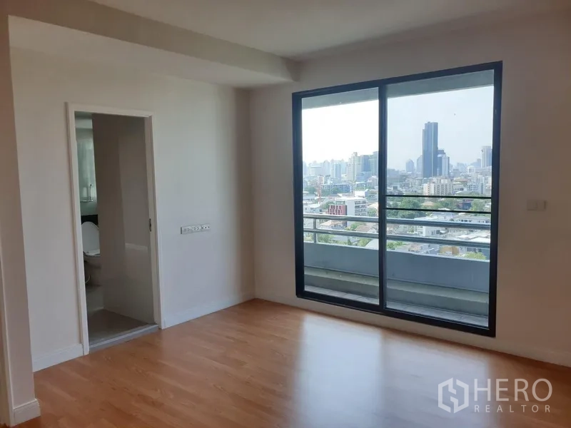 คอนโด ให้เช่าในWatthana, Bangkok - ห้องนอนมีห้องน้ำในตัวและประตูกระจกสู่ระเบียง พร้อมวิวเมือง