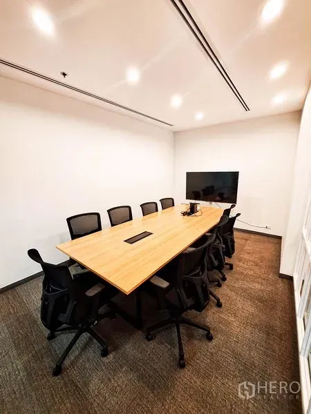 办公空间 出租在Bang Na, Bangkok - 现代会议室，长木桌、黑色椅子、吊顶射灯与墙挂电视。