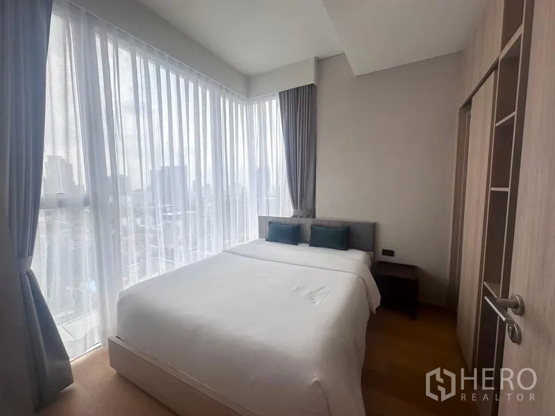 คอนโด ให้เช่า - ห้องนอนมุมกระจก เตียงคิงไซส์ ผ้าม่านโปร่งรับแสงธรรมชาติ