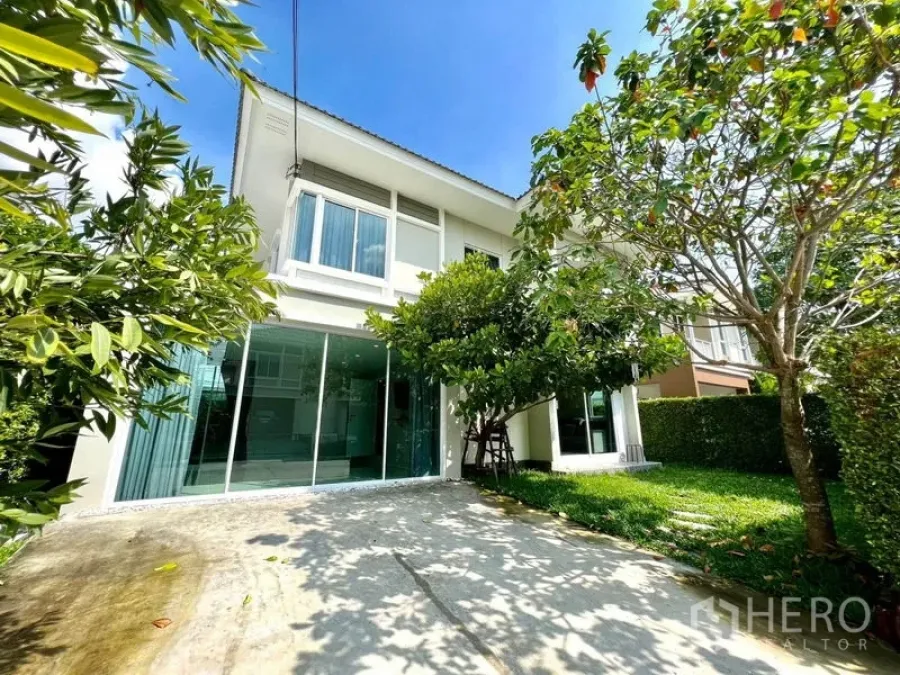 บ้าน ขายในBang Sao Thong, Samut Prakan - ภายนอกบ้านเดี่ยว 2 ชั้น มีลานจอดรถ สนามหญ้า ต้นไม้ใหญ่ และกระจกบานกว้าง