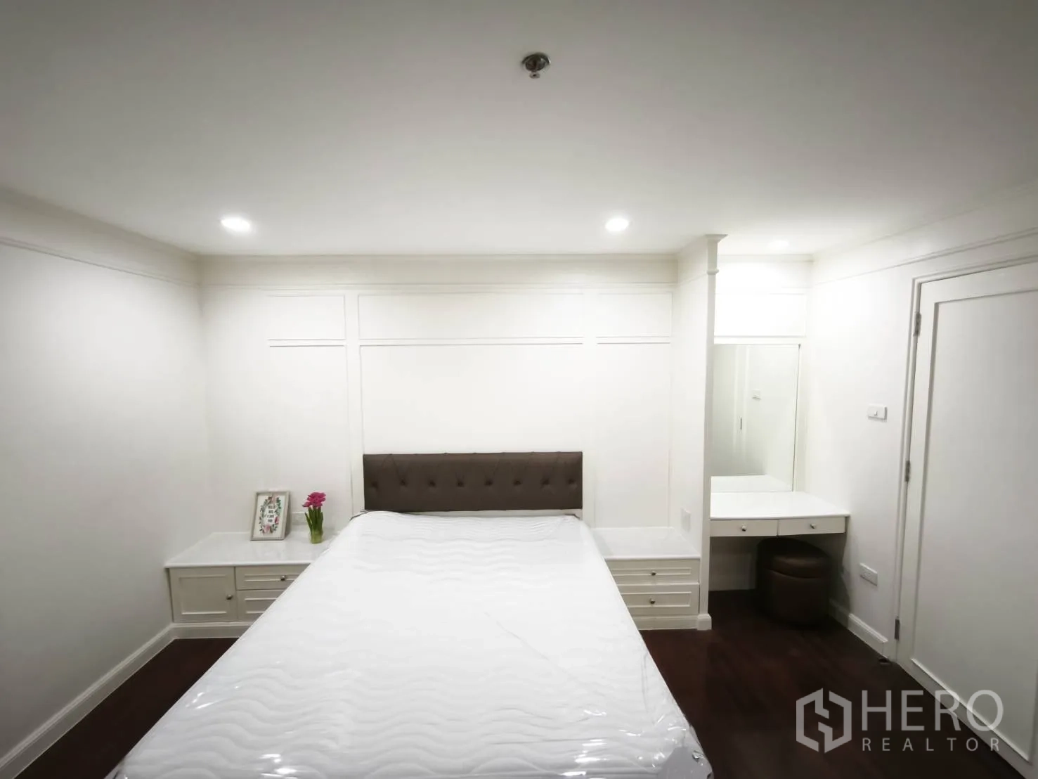 Condominium for rent in Watthana, Bangkok - Bedroom with bed, side tables, and a dressing corner with mirror and stool.