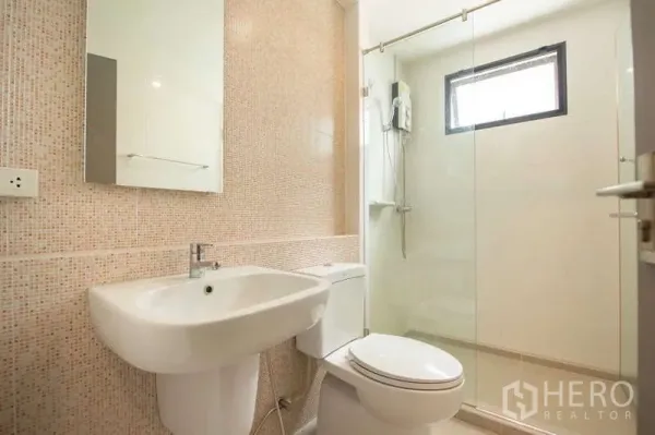 联排别墅 出租或出售在Lat Phrao, Bangkok - 现代浴室，玻璃淋浴房、坐便与镜面洗手台。