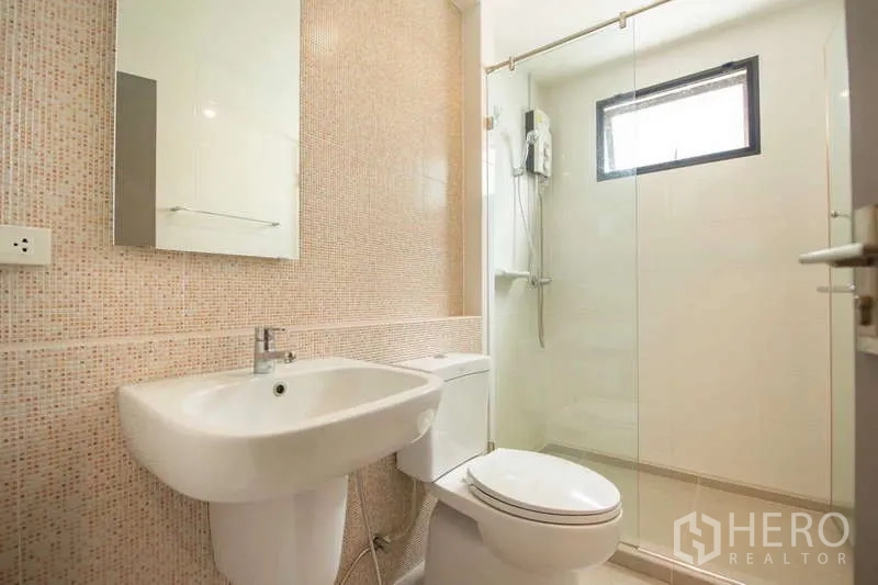 联排别墅 出租或出售在Lat Phrao, Bangkok - 现代浴室，玻璃淋浴房、坐便与镜面洗手台。