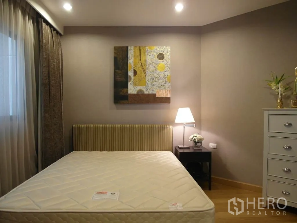 公寓 出租或出售在Sathon, Bangkok - 温馨次卧，配床垫、床头灯、挂画与窗帘。