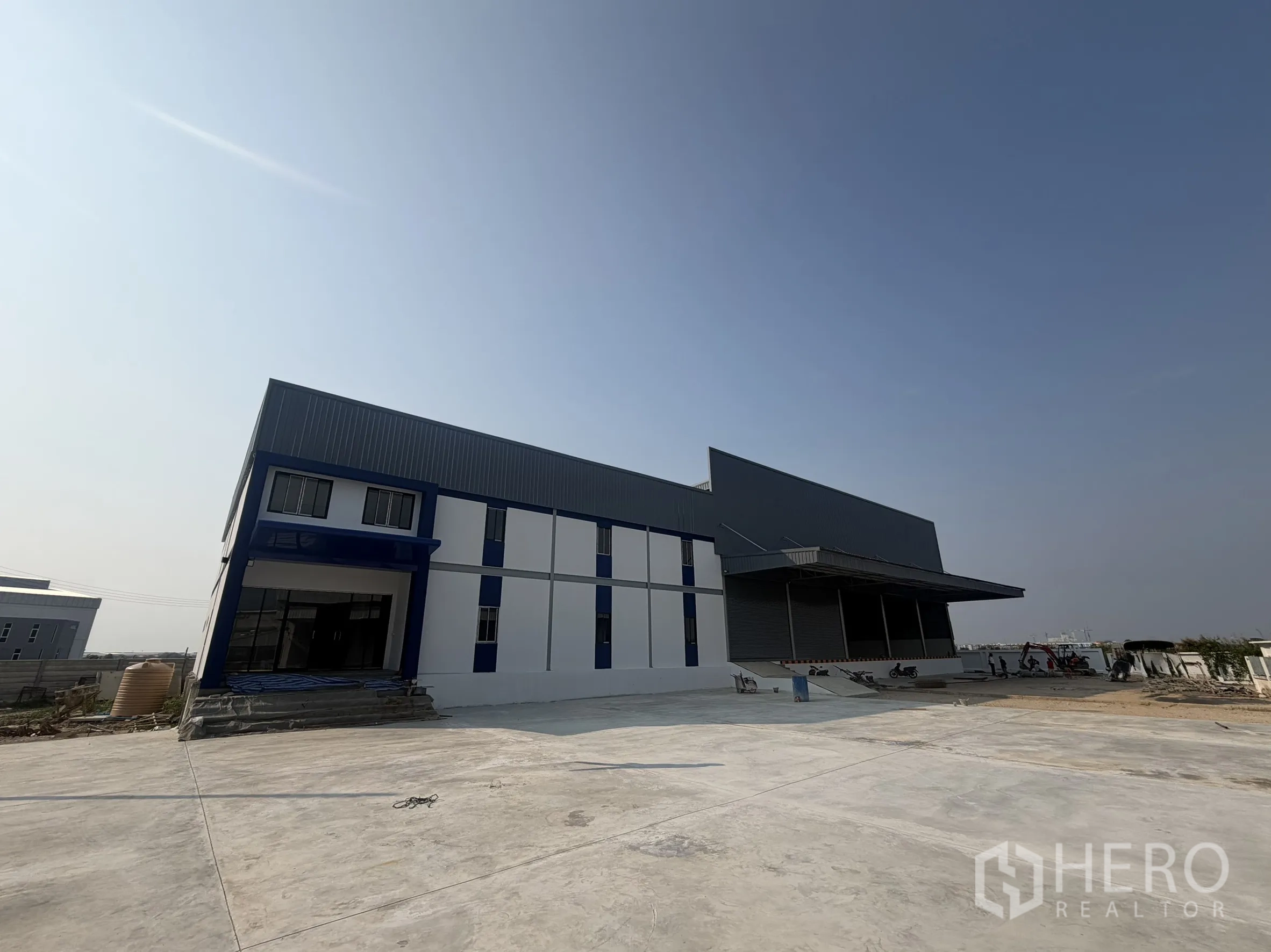 Warehouse for rent in Bang Bo, Samut Prakan - Exterior view of the new warehouse building with a wide paved yard.