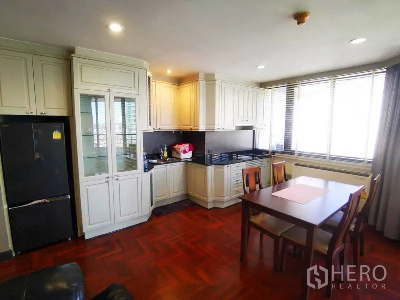 คอนโด ให้เช่าในKhlong Toei, Bangkok - ครัวสว่างตู้สีครีม เคาน์เตอร์สีดำ โต๊ะทานข้างหน้าต่างบานใหญ่