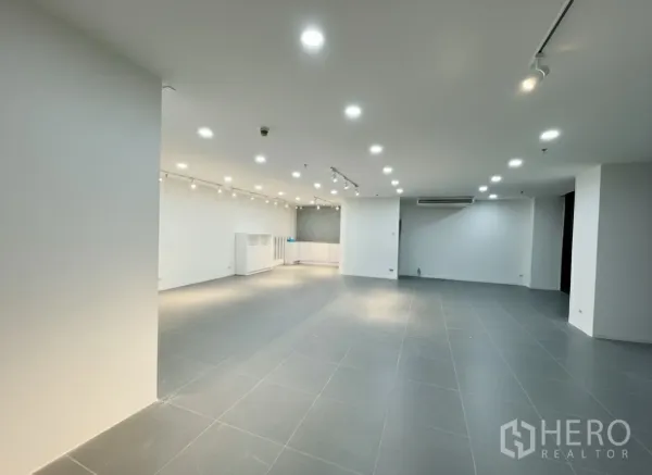 พื้นที่ขายปลีก ให้เช่า - ภายในแบบโอเพ่นสเปซ ปูกระเบื้องสีเทา ผนังสีขาว ไฟดาวน์ไลท์และรางสปอตไลท์