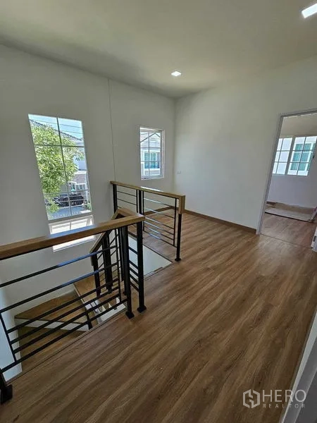Detached House for rent in Thanyaburi, Pathum Thani - Stair landing with metal handrail and wood-look floors filled with natural light