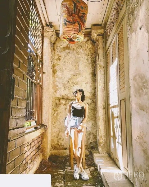 Shophouse for rent in Bang Rak, Bangkok - Narrow porch with textured walls, decorative hanging lantern and shuttered doors.