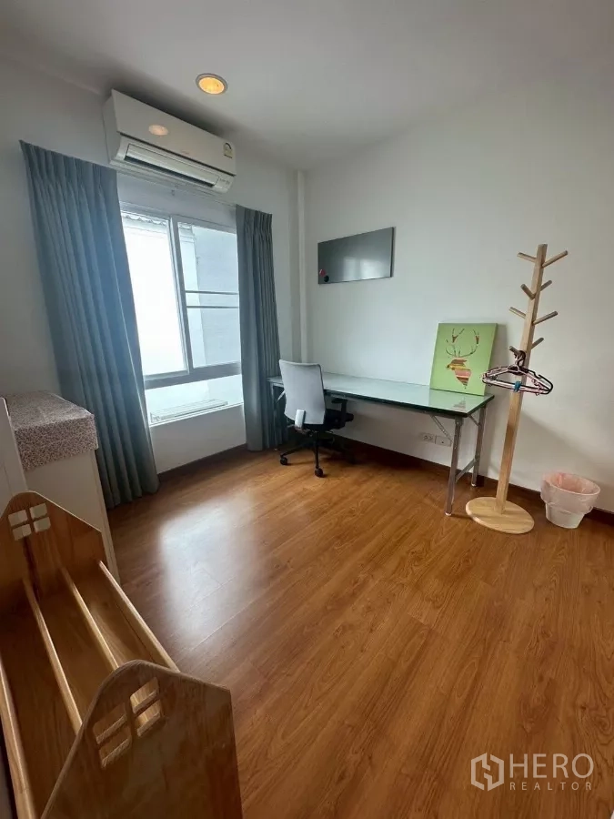 Townhouse for rent in Chom Thong, Bangkok - Secondary bedroom with study desk by the window and air conditioner.