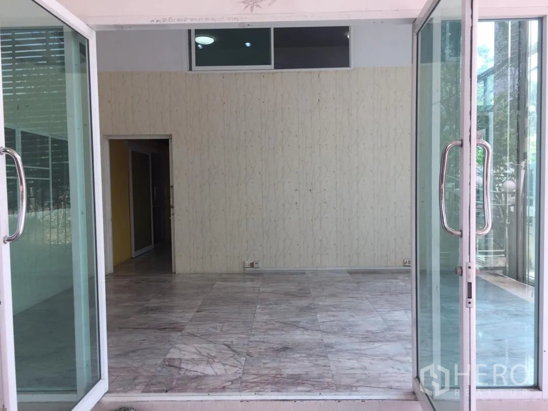 Home Office for rent or sale in Bang Khun Thian, Bangkok - Entrance foyer viewed through sliding glass doors with marble-look flooring.