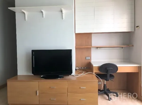 公寓 出租在Watthana, Bangkok - 明亮房间内的内置书桌、置物架和电视柜。