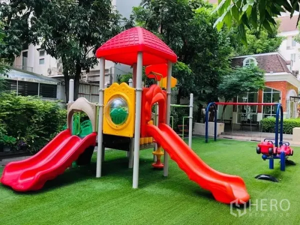 Townhouse for rent in Khlong Toei, Bangkok - Colorful outdoor playground with twin slides, swings and soft artificial grass.