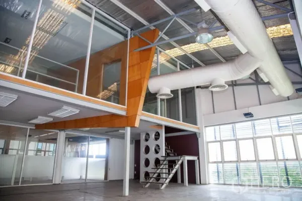 货栈 出租在Prawet, Bangkok - 玻璃幕墙夹层办公室，金属楼梯、大窗与白色风管，位于工业仓库内。