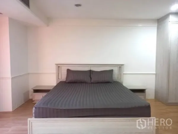 公寓 出租在Khlong Toei, Bangkok - 主卧配特大床、床头柜与木地板。