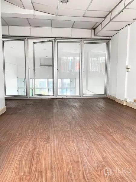 联排别墅 出租在Khlong Toei, Bangkok - 明亮房间，木纹地板与整面玻璃隔断门，联排别墅内景。