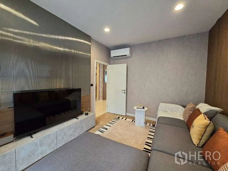 独立式住宅 出租在Bang Kapi, Bangkok - 电视起居室另一视角，影音墙与空调。