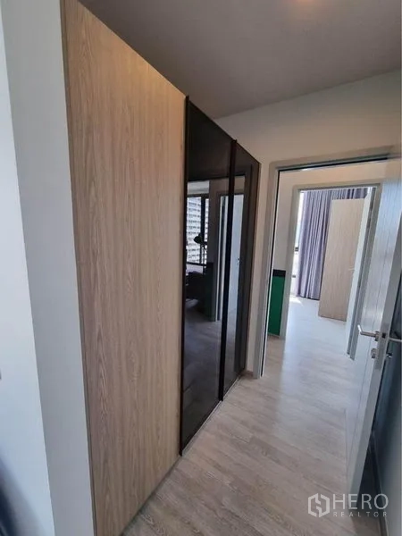 公寓 出租在Watthana, Bangkok - 走廊内置衣柜，木质与茶色玻璃门结合。