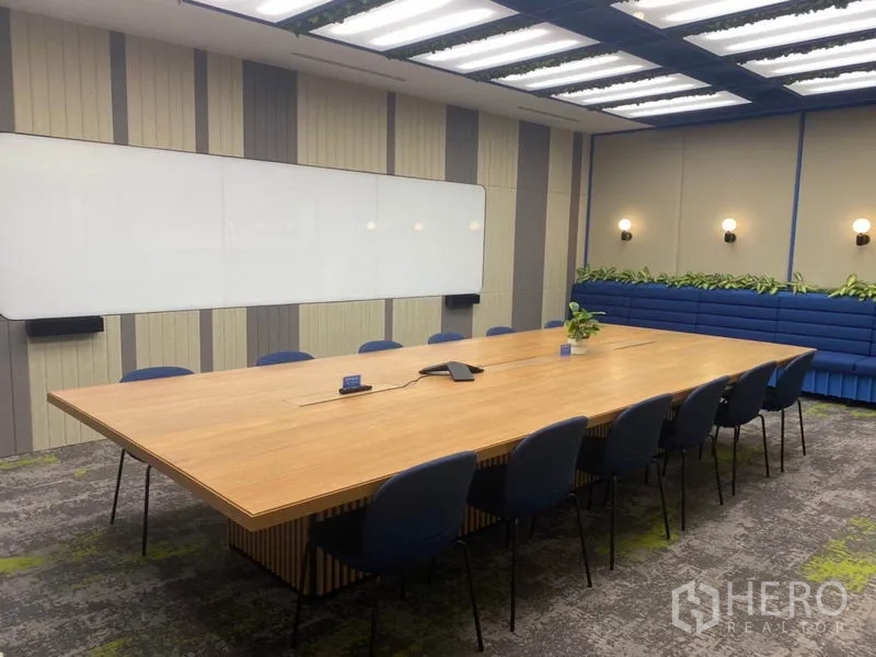 办公空间 出租在Pathum Wan, Bangkok - 会议室角度，内置长凳、绿植点缀与大型会议桌。