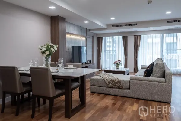 Apartment for rent - Dining area and lounge with floor-to-ceiling windows and balcony curtains.