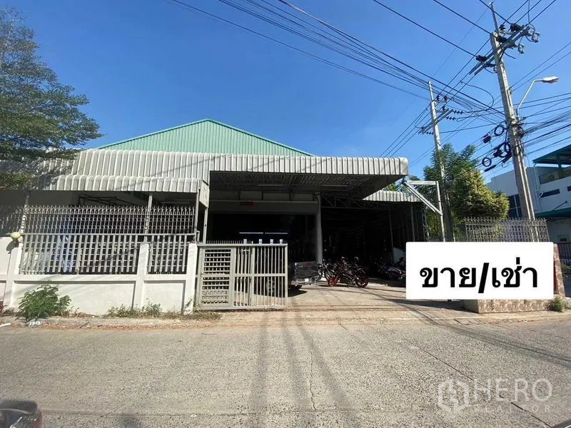 คลังสินค้า ให้เช่าหรือขายในMueang Samut Prakan, Samut Prakan - ด้านหน้าทางเข้าโกดังพร้อมรั้วและทางรถกว้างบนซอยเงียบสงบ