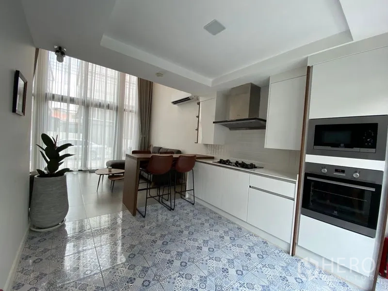 ทาวน์เฮาส์ ให้เช่าในSuan Luang, Bangkok - มุมครัวสว่างด้วยพื้นกระเบื้องลายแพตเทิร์น เตาอบบิวท์อิน และผ้าม่านสูงจรดเพดาน