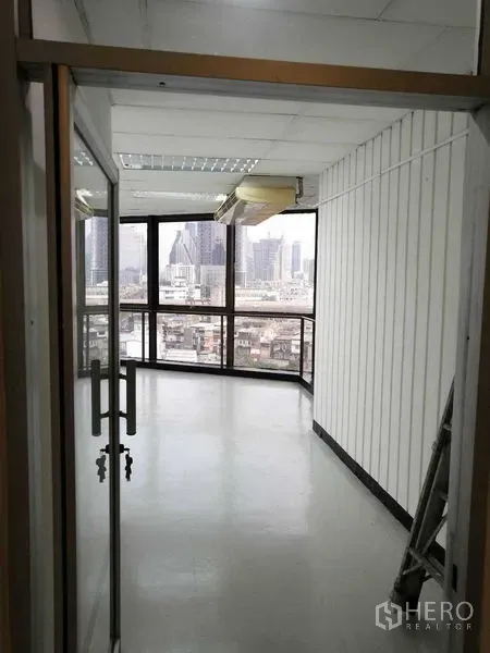 办公空间 出租在Bang Rak, Bangkok - 转角办公室，玻璃门与环幕窗，俯瞰曼谷天际线。