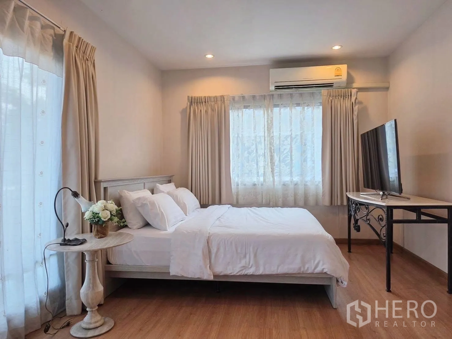 Detached House for rent or sale in Suan Luang, Bangkok - Bedroom with TV on console, air conditioner and sheer curtains.
